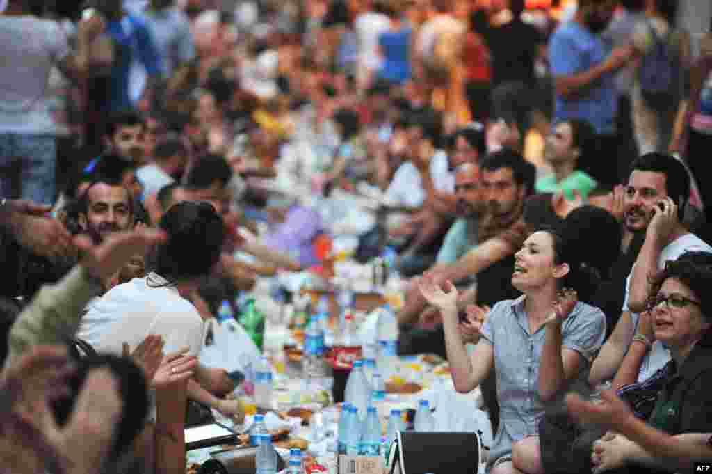 Demonstran anti-pemerintah di Turki meneriakkan slogan-slogan sebelum berbuka puasa hari pertama bulan Ramadan di jalan Istiklal, Istanbul (9/7). (AFP/Ozan Kose)