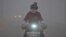 FILE - With a yellow smog alert in effect, a woman rides her electric bicycle along a street amid thick haze in Chiping county, Shandong province, China, Jan. 16, 2015.