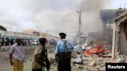 Tentara Somalia melihat dari kejauhan serangan bom bunuh diri di Mogadishu, Somalia (12/7). (Reuters/Omar Faruk)