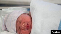 FILE - Newborn baby Makenzie, daughter of Stephanie Sanchez and Kenneth Vega, rests in a nursery after being born at 10:25am at Wyckoff Heights Medical Center in the Brooklyn borough of New York, Oct. 31, 2011. 