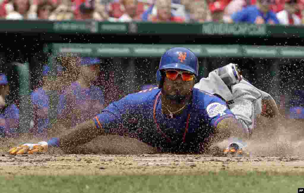 Pemain bisbol dari klub New York Mets, Jordany Valdespin, meluncurkan tubuhnya menyentuh home plate untuk membuat skor dalam&nbsp; RBI ganda oleh Daniel Murphy selama inning ketiga permainan bisbol melawan St Louis Cardinals di St Louis, 16 Mei 2013.