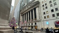FILE - A scooter passes the New York Stock Exchange in New York's Financial District, Dec. 17, 2024.