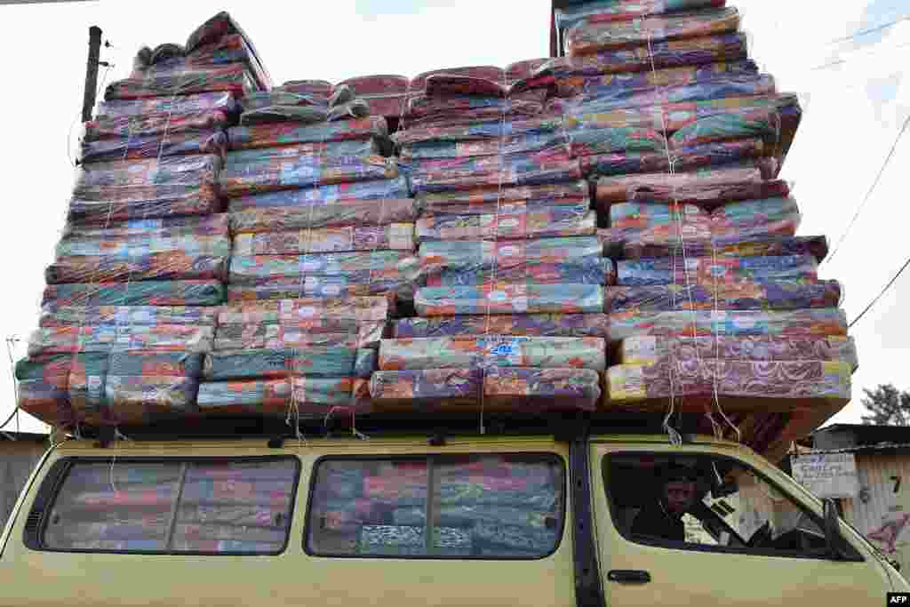 បុរស​ម្នាក់​ដឹក​ពូក​ជាច្រើន​នៅ​លើ​ដំបូល​ឡាន​តូច​មួយ​ក្នុង​តំបន់​អនាធិបតេយ្យ​ Ng&#39;ando ក្នុង​រដ្ឋធានី​ណៃរ៉ូប៊ី​នៃ​ប្រទេស​កេនយ៉ា​កាលពី​ថ្ងៃទី​១៦ មករា ២០១៨។