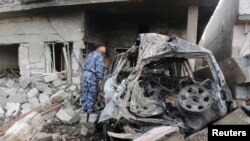 کرکوک میں جائے حادثہ پر سکیورٹی اہلکار تباہی کا جائزہ لے رہا ہے