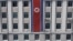 FILE - A pedestrian walks past a North Korean flag displayed on a building in Pyongyang, North Korea, April 12, 2019.
