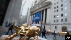 资料： 纽约证交所外面一位摊贩的桌上摆着象征牛市的公牛塑像。 