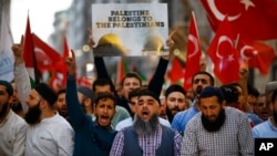 土耳其示威者手举国旗在伊斯坦布尔抗议美国大使馆从特拉维夫迁到耶路撒冷，一名示威者手举的标语写着：“巴勒斯坦属于巴勒斯坦人”。（5月14日）