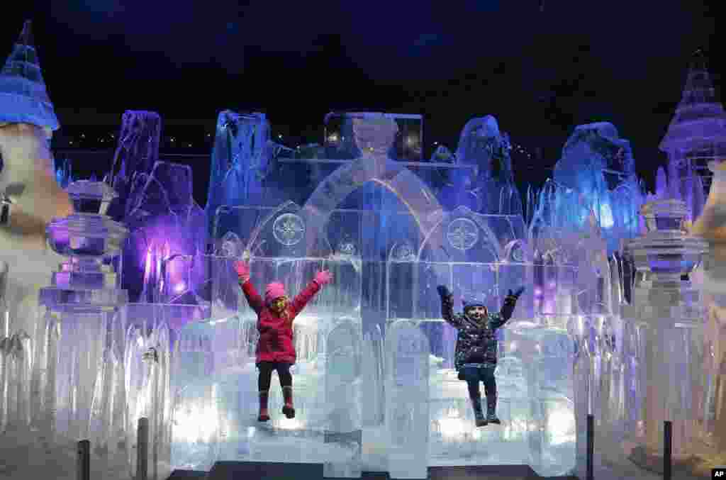Scarlett, 4, left, and Zoe, 3, enjoy sitting on a Throne of the castle ice sculpture at the launch of Hyde Park Winter Wonderland&#39;s Magical Ice Kingdom in London.