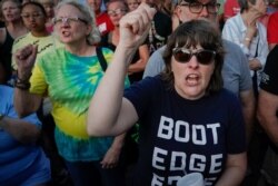 FILE - People shout "Do Something!" as Ohio Governor Mike DeWine speaks during a vigil at the scene of a mass shooting in Dayton, Ohio, Aug. 4, 2019.