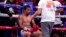 FILE - Trainer Freddie Roach speaks to Manny Pacquiao between rounds against Yordenis Ugas, of Cuba, in a welterweight championship boxing match in Las Vegas, Aug. 21, 2021. Pacquiao is officially hanging up his gloves. FILE - Trainer Freddie Roach speaks