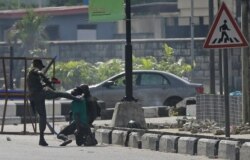 Police officers detain a protester at the Lekki toll gate in Lagos, Nigeria. After 13 days of protests against alleged police brutality, authorities have imposed a 24-hour curfew in Lagos.
