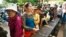 Cambodian villagers line up to cast their vote in the country's national election at a polling station at Chak Angre Leu pagoda, in Phnom Penh, Cambodia, Sunday, July 28, 2013. 