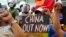 FILE - Protesters hold slogans during a rally in front of the Chinese Consulate in Makati city, Philippines, July 12, 2021. Chinese ships blocked two Philippine supply boats in the South China Sea, Manila’s top diplomat said Nov. 18, 2021.