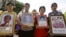 Relatives of the victims hold portraits of their loved ones during a commemorate session of a rally at Ratchaprasong Intersection in Bangkok, Thailand, May 19, 2012.