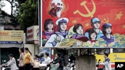 2006年4月16日越南人骑车经过巨型宣传海报(资料照片)