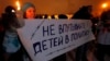 FILE - Russian child's death follows international controversy over the Russian ban on U.S. adoptions; protest sign says "Do not involve children in politics," St. Petersburg, Dec. 26, 2012.