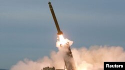 북한이 지난 24일 '초대형 방사포'를 시험발사하는 모습을 북한 관영 '조선중앙통신'이 보도했다. 사진에서 차륜형 발사대에 4개의 관이 식별된다.