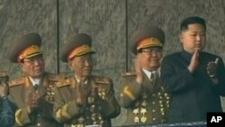 노동당 창건 65주년기념 행사로 김일성 광장에서 열린 대규모 열병식을 참관하기위해 주석단에 오른 김정은(우)