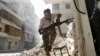 A Free Syrian Army fighter takes cover during clashes with Syrian Army in the Salaheddine neighborhood of central Aleppo in this August 7, 2012 file photo. 