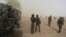 FILE - Cameroonian soldiers stand guard amidst dust kicked up by a helicopter in Kolofata, Cameroon, March 16, 2016. Part of a multinational force, the soldiers have intensified their fight against Boko Haram militants.