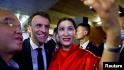 2023年4月5日，法国总统马克龙在中国北京红砖美术馆与参加活动者合影。（路透社照片）