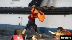 Réfugiés recueilli par un catamaran après avoir traversé une partie de la mer Égée entre la Turquie et l'île grecque de Lesbos, le 30 Octobre 2015. (Photo REUTERS/Giorgos Moutafis)