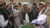 Afghan men pray during the funeral of Najia Sidiqi, the acting director of the women's affairs department in Mihtarlam, December 10, 2012.