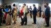 FILE - People are seen waiting in line to meet with recruiters during a job fair in Philadelphia, Pennsylvania.
