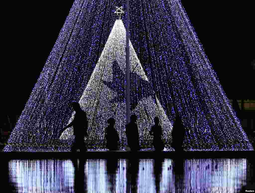 Warga setempat melewati sebuah dekorasi Natal di pusat kota Kolombo, Sri Lanka. 