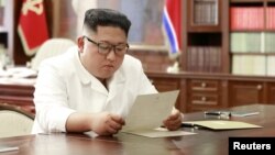 North Korean leader Kim Jong Un reads a letter from U.S. President Donald Trump, in Pyongyang, North Korea, in this picture released by North Korea's Korean Central News Agency, June 22, 2019.