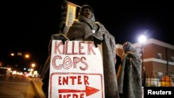 17일 미국 미주리주 퍼거슨 시 경찰서 앞 시위대가 흑인 청년 마이클 브라운이 경찰의 총에 맞아 사망한 사건과 관련하여 항의하고 있다.