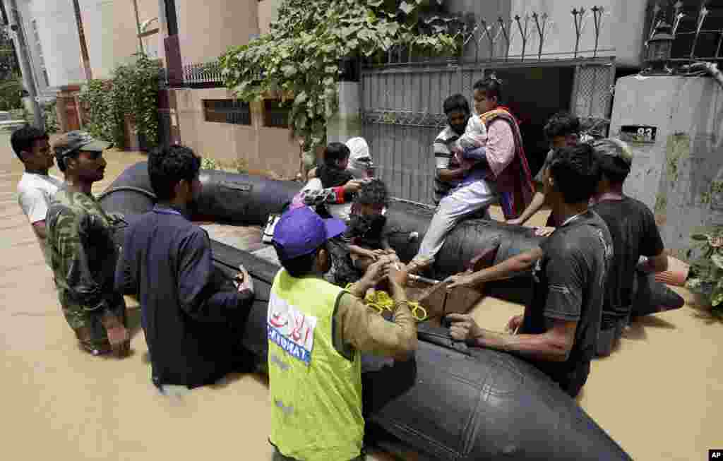 Pakistani soldiers rescue a family from an area flooded by heavy rains on the outskirts of Karachi, Pakistan, August 4, 2013.&nbsp;