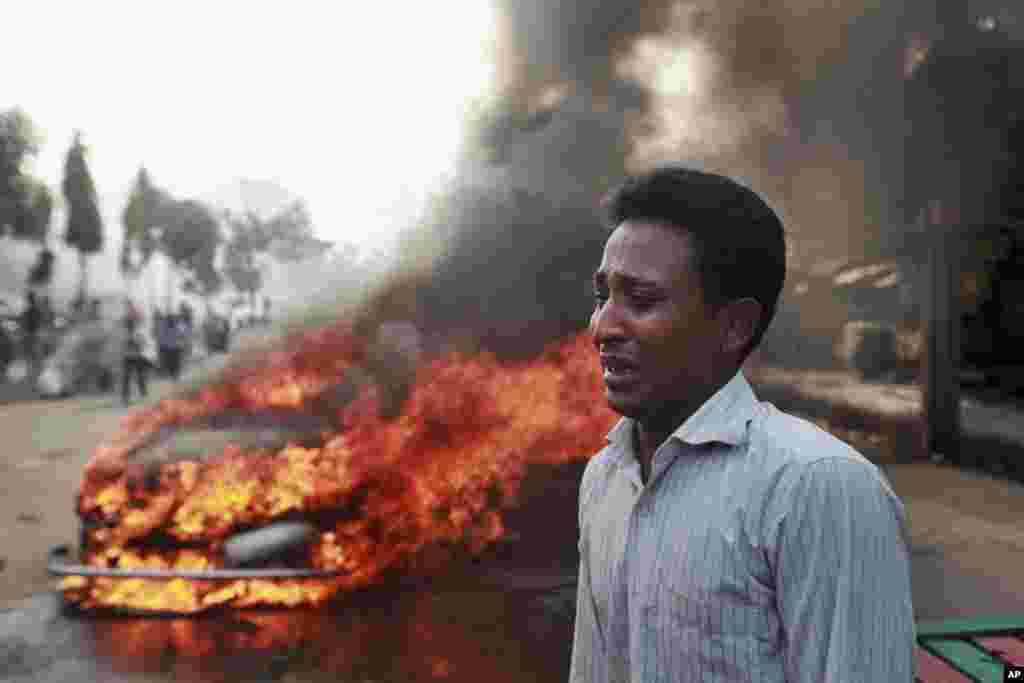 Seorang laki-laki Bangladesh menangis setelah mobilnya dibakar oleh aktivis partai Islam Jamaat-e-Islami dalam unjuk rasa yang diwarnai kekerasan menyusul dihukum matinya pemimpin partai mereka, Abdul Quader Mollah, di Dhaka. 