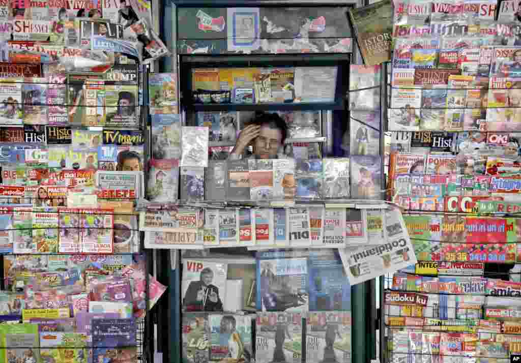 Seorang penjual memajang koran dan majalahnya di dekat stasiun kereta, Gara de Nord, di Bukares, Romania.