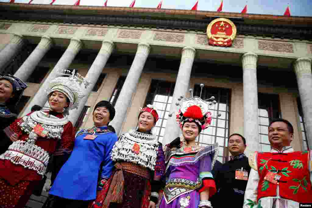 2018年3月5日在北京举行的中国人大开幕会前，穿戴少数民族服饰的代表站在人民大会堂外。