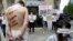 FILE - Reporters Without Borders activists, bound and made up as mock victims, demonstrate outside the Iran Air office on the Champs Elysées in Paris, July 10, 2012, to protest the imprisonment of Iranian journalists.