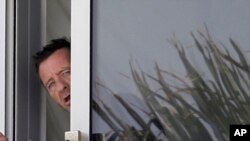 Phil Rudd, penabuh drum band rock AC/DC, melongok dari sebum gondola di rumahnya di Tauranga, Selandia Baru (6/11).