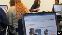 FILE - Staff members from the Champaign Urbana Public Health District offices in Champaign, Ill., work with people trying to sign up for health care coverage through the Affordable Care Act, Oct. 1, 2013. 