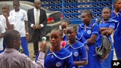 利比里亚教师给高中生量体温，防范埃博拉