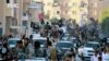 FILE - Islamic State fighters parade in Raqqa, Syria, June 30, 2014. A former British spy chief said militants at that point had more than doubled the recruitment of foreign fighters, to as much as 31,000, over the previous 18 months.