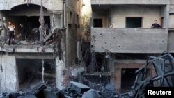 2024年12月13日，巴勒斯坦人在以色列袭击加沙地带中部努塞拉特难民营现场勘察损坏的情况。