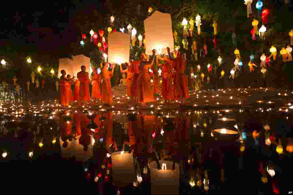 Biksu Budha mempersiapkan diri untuk melepaskan lentera setelah upacara pemberkatan selama upacara keagamaan Loy Krathong di sebuah kuil di Chiang Mai, Thailand.