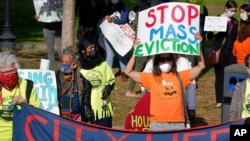 FILE - Protesters display placards while calling for support for tenants and homeowners at risk of eviction during a demonstration on the Boston Common, in Boston, Oct. 11, 2020.