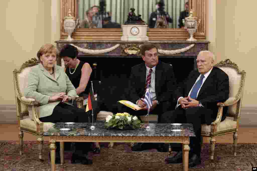 Greek President Karolos Papoulias, right, attends a meeting with German Chancellor Angela Merkel, left, at the Presidential palace in Athens, Greece, October 9, 2012.