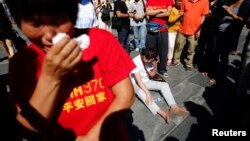 말레이시아 여객기 MH370편이 실종된 지 6개월을 맞은 지난달 8일, 베이징에서 추모 기도회에 참석한 유가족들이 울고 있다.