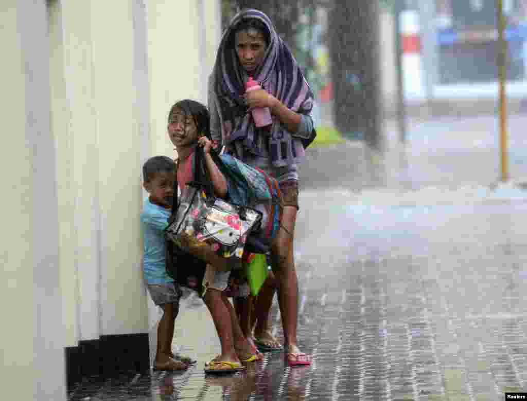 A mother takes refuge with her children as Typhoon Haiyan hits Cebu city, central Philippines, Nov. 8, 2013. 