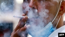 FILE - A Jordanian man smokes a cigarette in the capital Amman, March 17, 2021. 