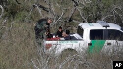 FILE - U.S. Customs and Border Patrol agents stop a group of suspected illegal immigrants passing through a ranch near Edinburg, Texas, Nov. 15, 2016.