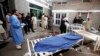 Relatives stand next to the body of a man in Lady Reading Hospital in Peshawar, March 21, 2013.
