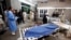 Relatives stand next to the body of a man in Lady Reading Hospital in Peshawar, March 21, 2013.